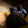 Un soldat de la MINUSMA , coiffé d'une casquette bleue et portant une écharpe, s'entretient avec un homme local portant un turban, recueillant des témoignages à Tombouctou, au Mali.