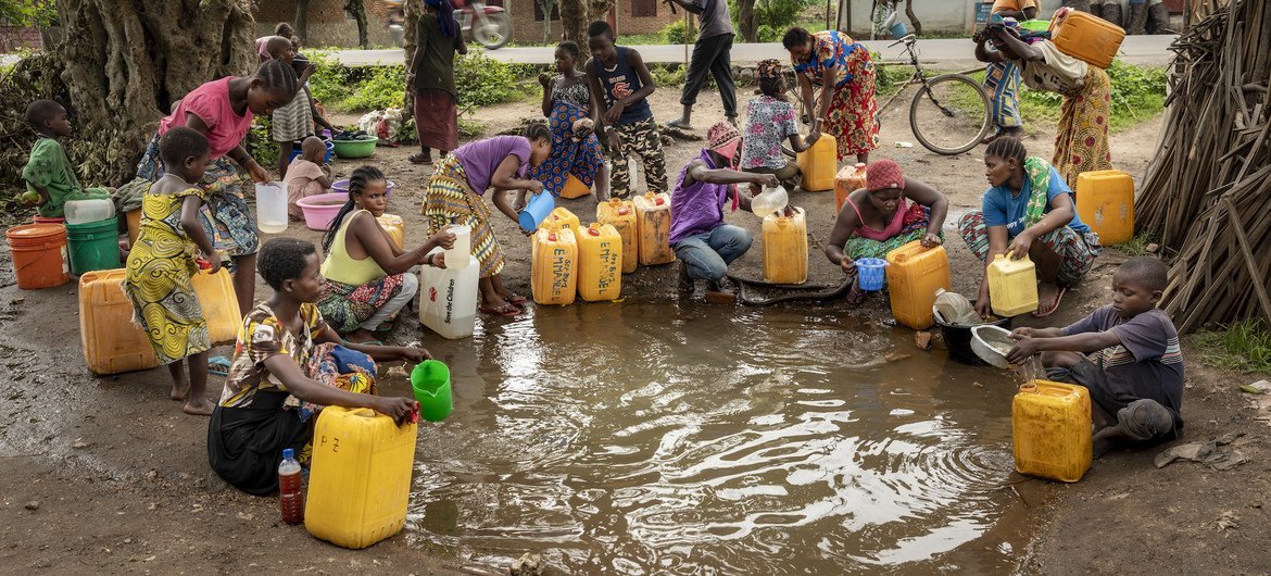Displaced persons collect water after a previous flood in DR Congo.