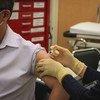 Житель Макао, Китай, получает прививку от COVID-19