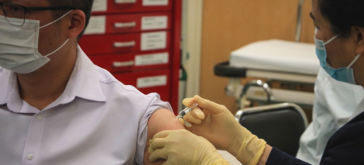Un homme se faisant vacciner contre le virus COVID-19 à Macao, en Chine.