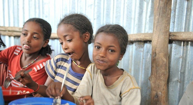 Tres niñas etíopes reciben un almuerzo escolar todos los días en una escuela beneficiada por el PMA.