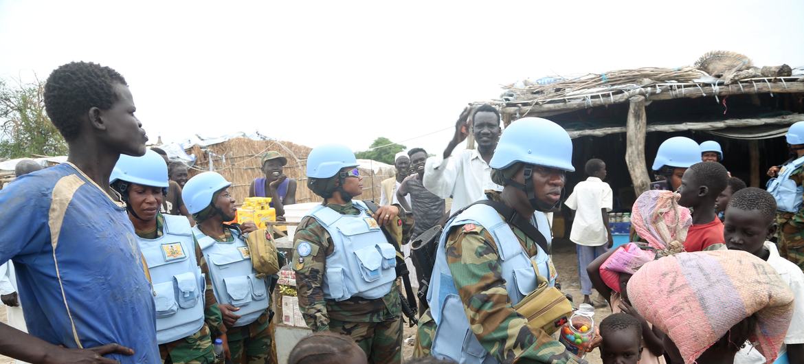 Le commandant du peloton d'engagement ghanéen de la FISNUA, la capitaine Cecilia Arzua, Défenseur militaire de l'égalité des sexes de l'ONU pour 2022, distribue des bonbons à des enfants d'Abyei.