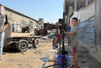 Children collect water in northern Gaza.