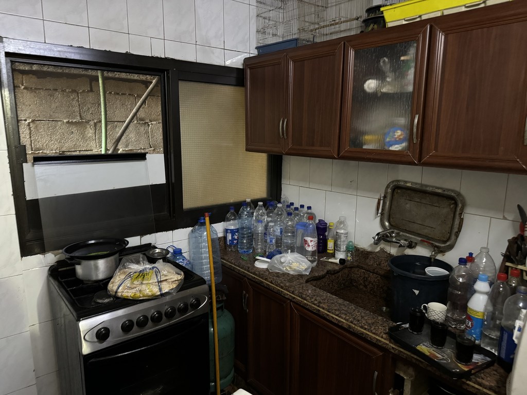 La cuisine d'Ahmad ne contient que des bouteilles d'eau vides et un sac de pain.