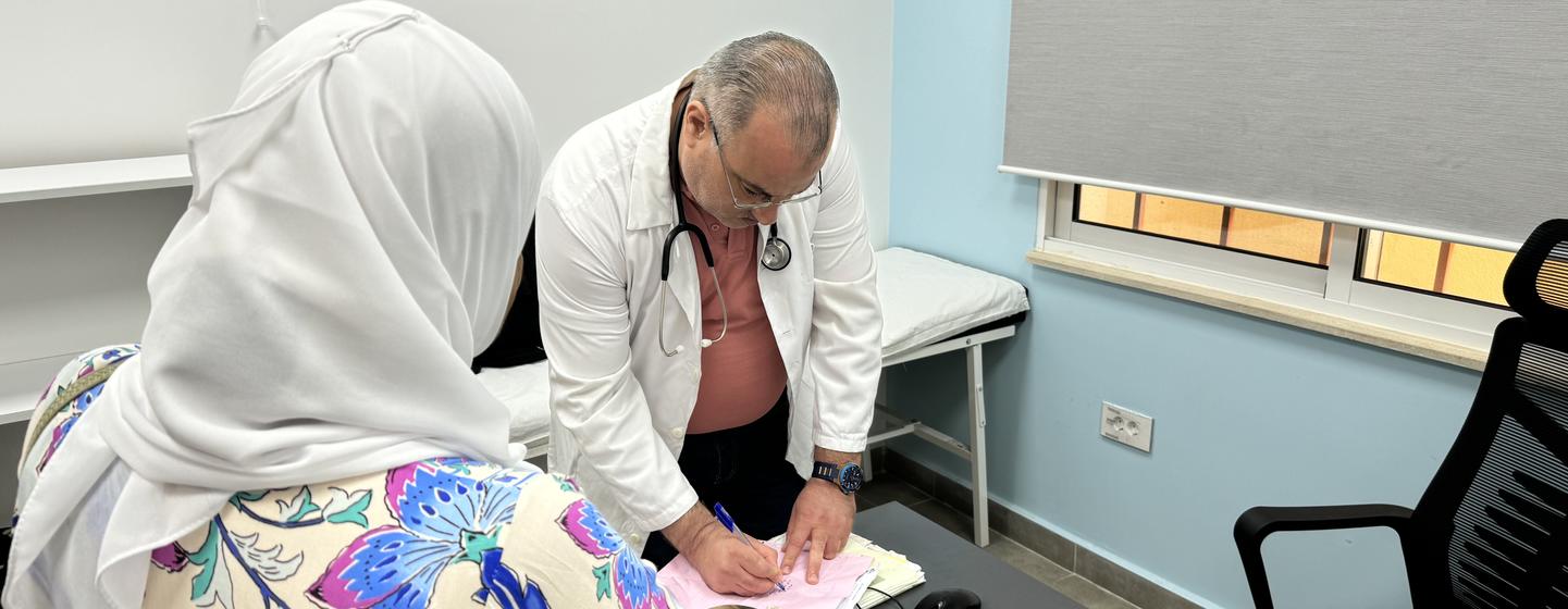 Глава медицинского центра БАПОР в Аль-Баддави с пациенткой.