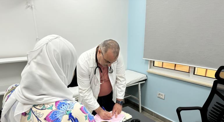الدكتور محمد بدران، مسؤول مركز الأونروا الصحي في مخيم البداوي، يعالج إحدى المرضى.