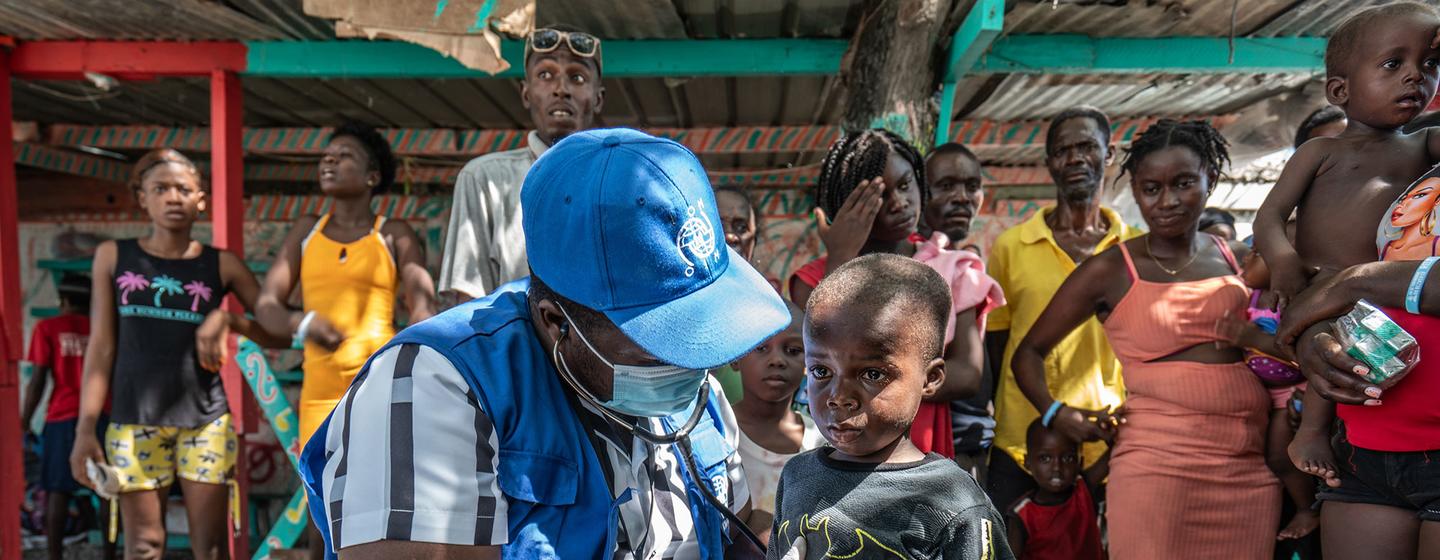 Des Haïtiens déplacés et sans-abri se rassemblent pour recevoir des soins médicaux gratuits dans une clinique mobile de l'OIM sur la place Clercine à Tabarre, Port-au-Prince.