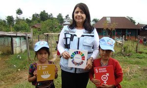 The UN Resident Coordinator in Guatemala, Rebeca Arias, Flores promotes the Sustainable Development Goals with the help of two young children.