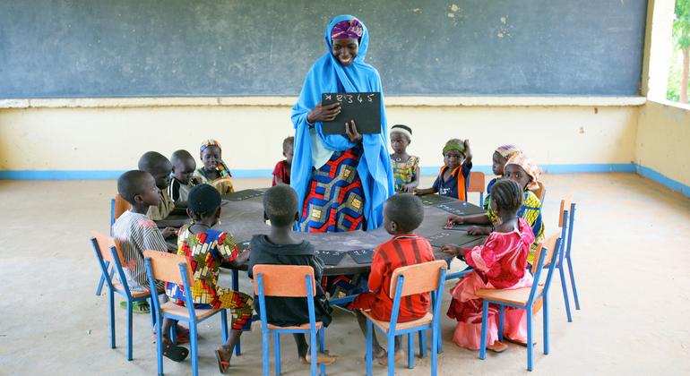 أطفال يجلسون في حلقة مع معلمهتم في مركز تنمية الطفولة المبكرة في قرية غارين بادجيني، جنوب شرق نيجيريا.