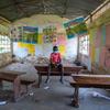 Menino de 12 anos na sala de aula vazia de uma escola que foi fechada durante a pandemia de Covid-19