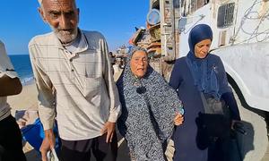 Desplazamiento en Gaza: Abu Nader Siam (izquierda), caminando con su esposa Zakia Siam (centro).