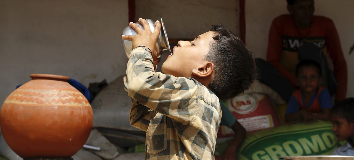 Un enfant boit de l'eau dans un pot en terre cuite pendant une vague de chaleur au Rajasthan, en Inde.