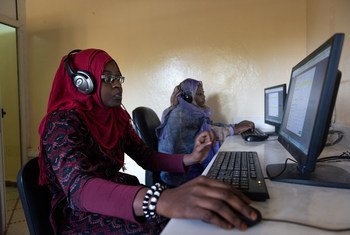À Nouakchott, en Mauritanie, une femme portant un hijab rouge et des lunettes utilise un ordinateur dans un centre d'emploi pour mettre en relation les demandeurs d'emploi et les employeurs.