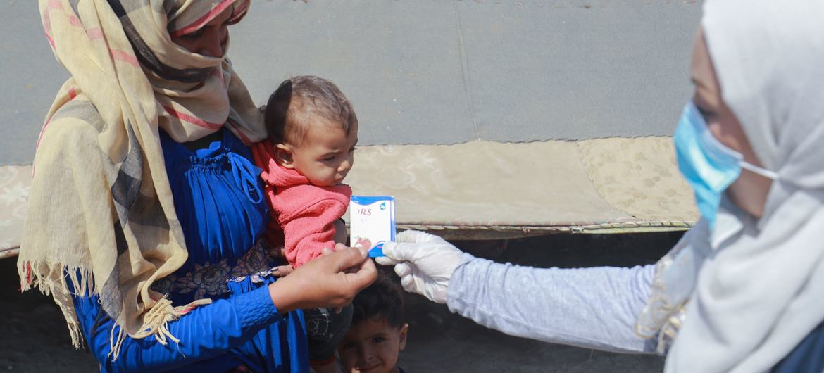 A mother in Raqqa city, Syria, goes to get medicine for her child with diarrhea and is also taught how to disinfect water to prevent cholera.