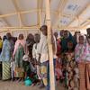 Um grande grupo de recém-chegados espera para se registrar dentro de uma estrutura no campo de Minawao para refugiados nigerianos na região do extremo norte