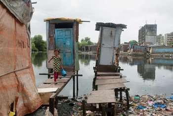在印度孟买，一个小女孩从简易厕所中出来，那里的排泄物被直接排放到开放水源中。