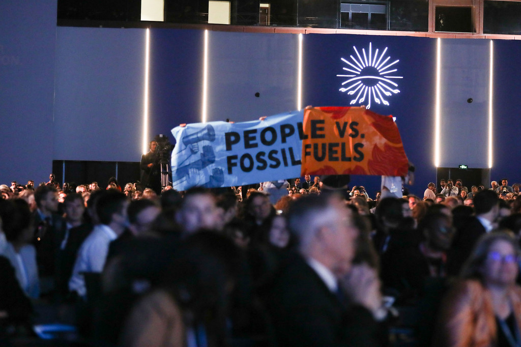 Protesters hold a 'People vs. Fossil Fuels' banner at the COP27 conference in Sharm el-Sheikh, Egypt.