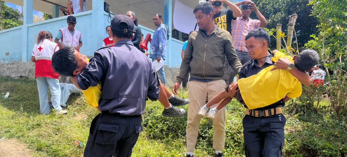 Moradores da vila de Orlalan, Timor-Leste, simulam uma operação de resgate de deslizamento de terra