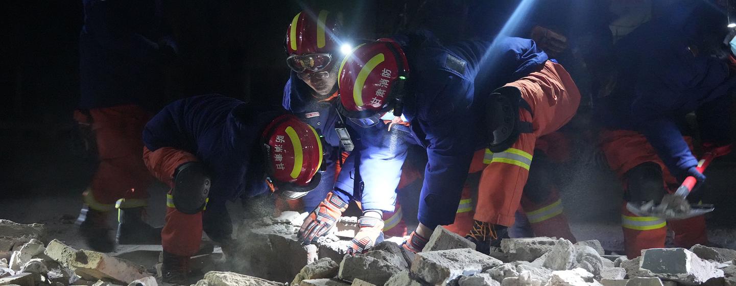 12月19日晚，平凉市消防救援支队消防救援人员在周家村为受灾群众清理道路、搬运物资、搜寻火炉。