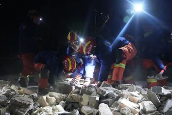 12月19日晚，平凉市消防救援支队消防救援人员在周家村为受灾群众清理道路、搬运物资、搜寻火炉。