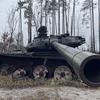 Поврежденный танк стоит в лесу в городе Буча, Украина.