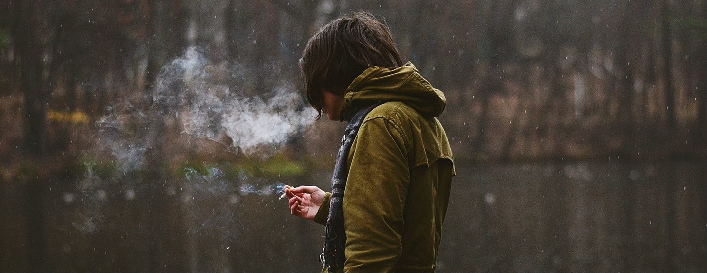 Un homme fume une cigarette.
