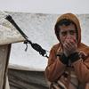 من الأرشيف: فتى ينفخ في يديه للشعور بالدفء في مخيم كللي في إدلب، شمال غرب سوريا.