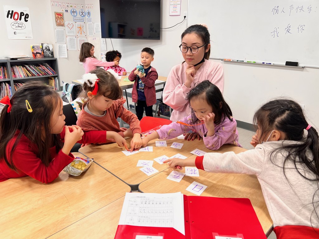林佳晖老师在与小朋友们玩识字卡游戏。