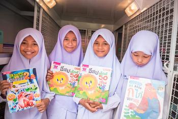 在泰国南部，以北大年-马来语为母语的学生举着他们最喜欢的读物。