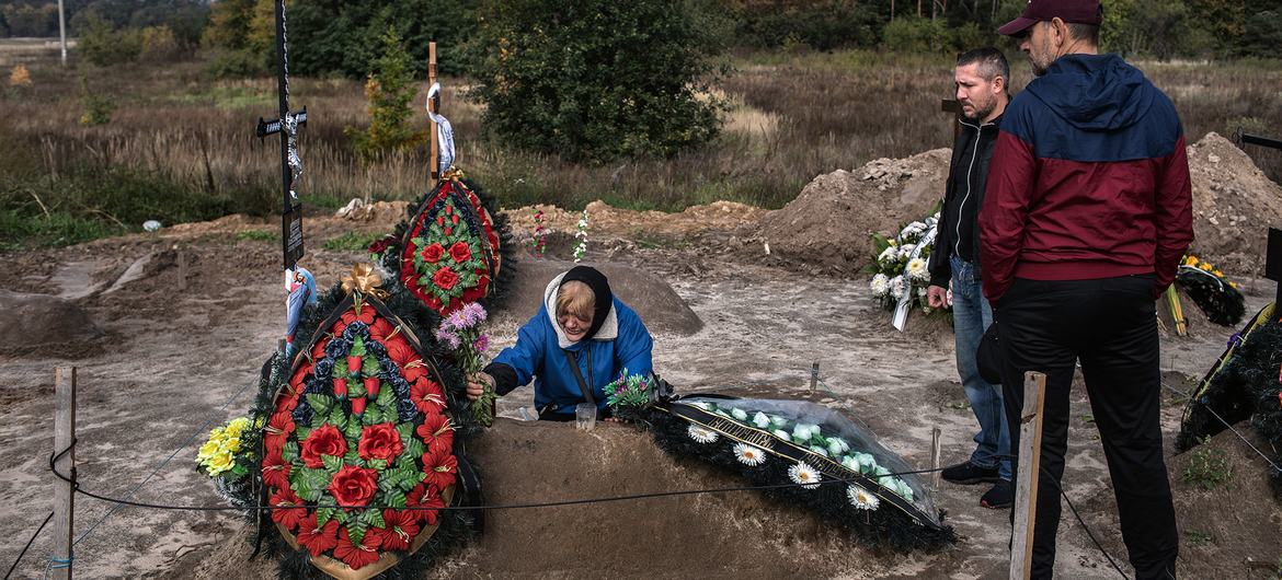 यूक्रेन के बूचा में, एक माँ ने अपने बेटे के शव को 450 अन्य मृतकों के साथ दफ़नाया है.