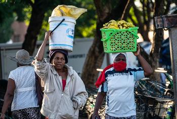 Fruit vendors walk through a market in Harare, Zimbabwe.
