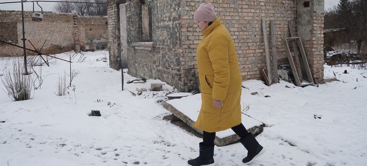 Женщина у своего разрушенного дома в Киевской области.