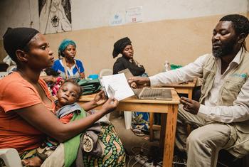 Une femme de la province du Sud-Kivu, en République démocratique du Congo, reçoit un téléphone portable de l'UNICEF afin de pouvoir recevoir des transferts monétaires pour subvenir aux besoins de sa famille.