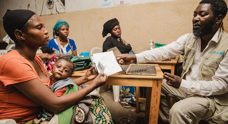 Une femme de la province du Sud-Kivu, en République démocratique du Congo, reçoit un téléphone portable de l'UNICEF afin de pouvoir recevoir des transferts monétaires pour subvenir aux besoins de sa famille.