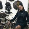 Lorna Zita, de Moçambique, está sentada numa galeria de arte rodeada por esculturas de metal.