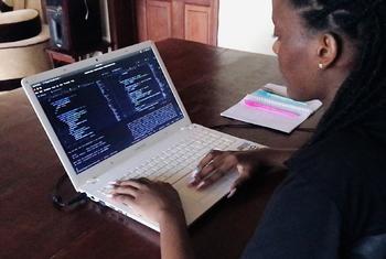 卡琳（Carine）是一名软件工程师，她正在卢旺达基加利的家中使用平板电脑为她正在开发的应用程序 Save 和 Save+ 进行后端编码。