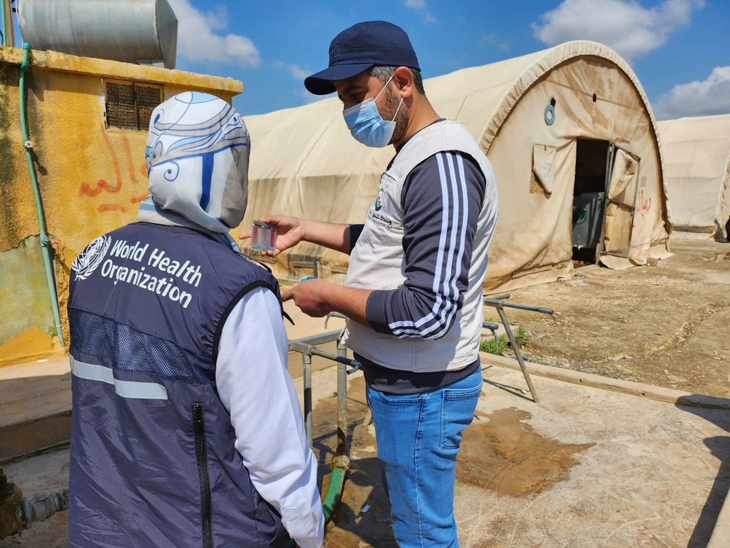 موظفو منظمة الصحة العالمية يختبرون مياه الشرب في مركز استقبال شمال غرب سوريا.
