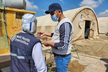 Miembros del personal de la Organización Mundial de la Salud analizan el agua potable en un centro de acogida del noroeste de Siria.