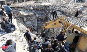 Excavadoras y maquinaria retiran los escombros de una casa destruida en la ciudad de Gaza, en busca de personas desaparecidas bajo los escombros.