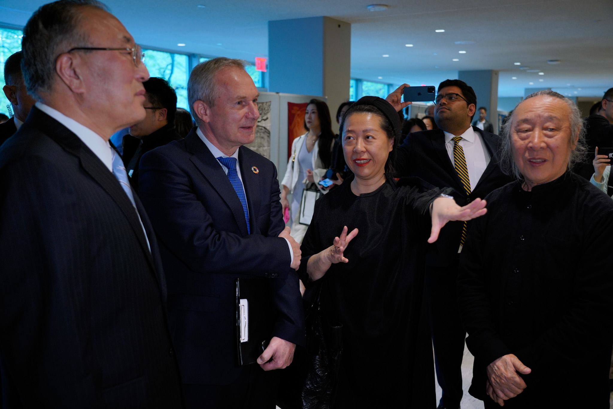 在中国常驻联合国代表及艺术家的陪同下，联大第77届会议主席克勒希参观中文日书法展。
