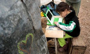 A young girl uses a computer to study, highlighting the power of digital learning to open up new opportunities for children everywhere.
