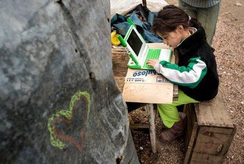 A young girl uses a computer to study, highlighting the power of digital learning to open up new opportunities for children everywhere.