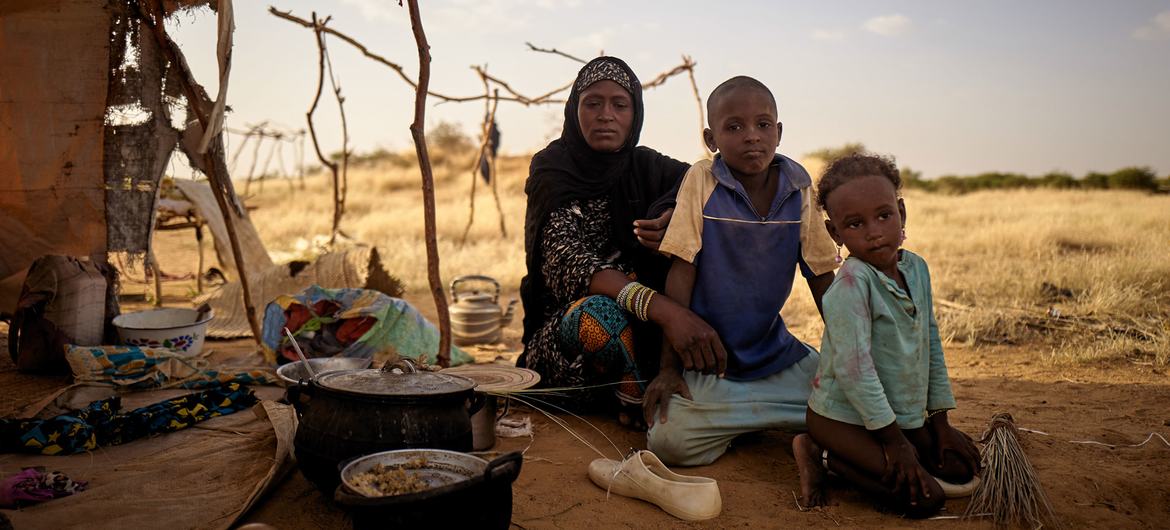 A displaced family sit in front of their tent at an informal camp in Bagoundié in Mali.