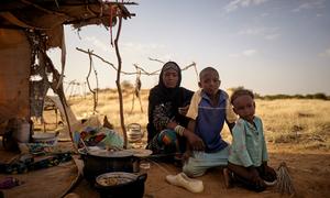 A displaced family sit in front of their tent at an informal camp in Bagoundié in Mali.