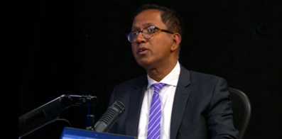 Hamid Rashid, economista, habla desde un podio con micrófono durante una presentación.