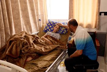 Ibrahim Al-Banna, sentado junto a su hijo Karim, herido de gravedad, lo consuela tras recibir el impacto de metralla cerca del riñón.