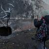 A teenager takes a photograph of a work by British street artist Banksy in the spring of 2023 in Irpin, Ukraine..