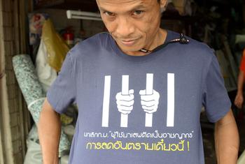 泰国一名活动人士穿着一件 T 恤，呼吁不要将那些采取减少毒品危害措施的人定为犯罪。