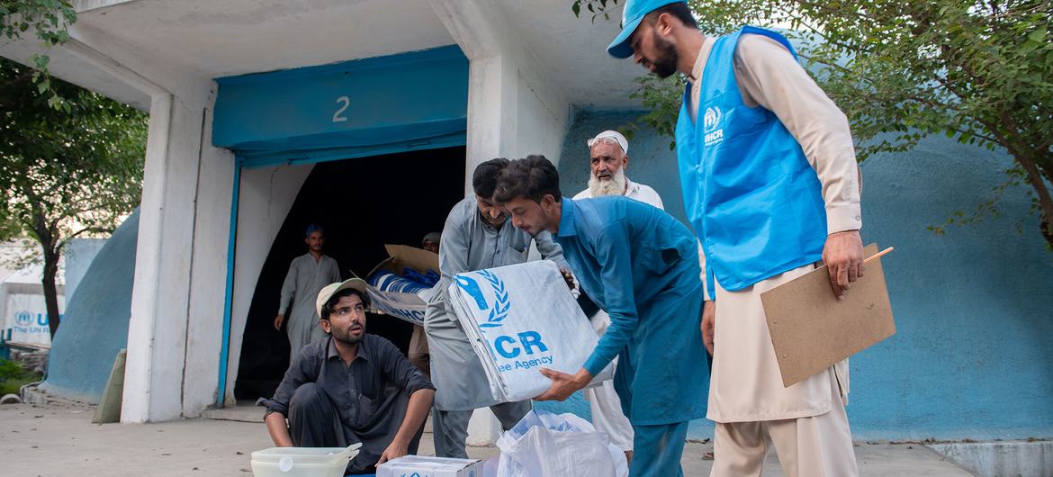 难民署工作人员在巴基斯坦西北部开伯尔-普赫图赫瓦省的一个难民村向阿富汗难民运送紧急救济物品。
