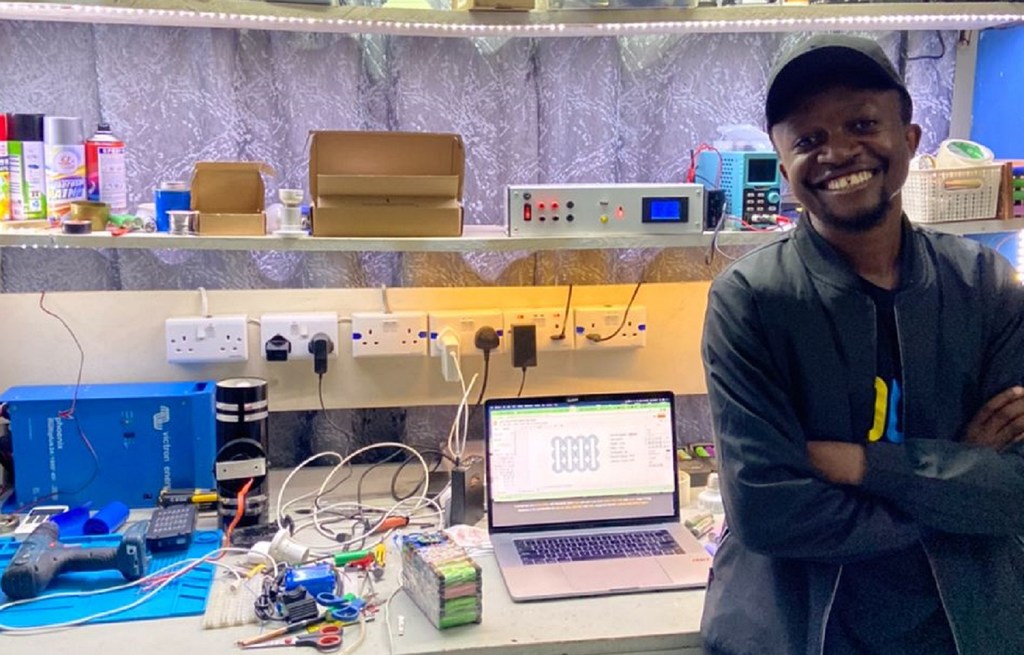 Gibson Kawago, membre de la promotion 2022 des jeunes leaders de l'ONU, originaire de Tanzanie, dans son atelier où il fabrique des produits alimentés par des piles à partir de batteries lithium-ion recyclées.